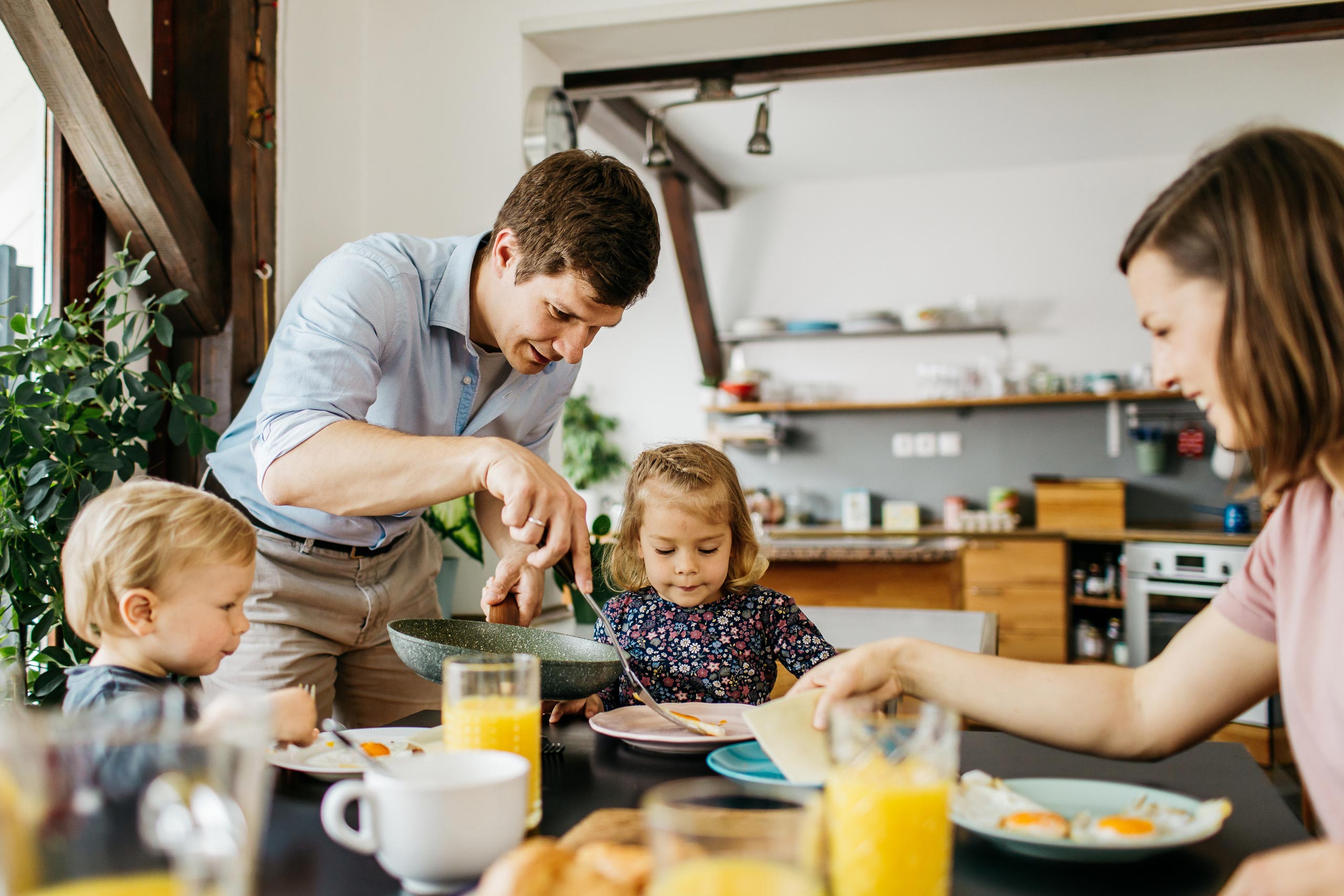 Two parents and two young children enjoying a family meal